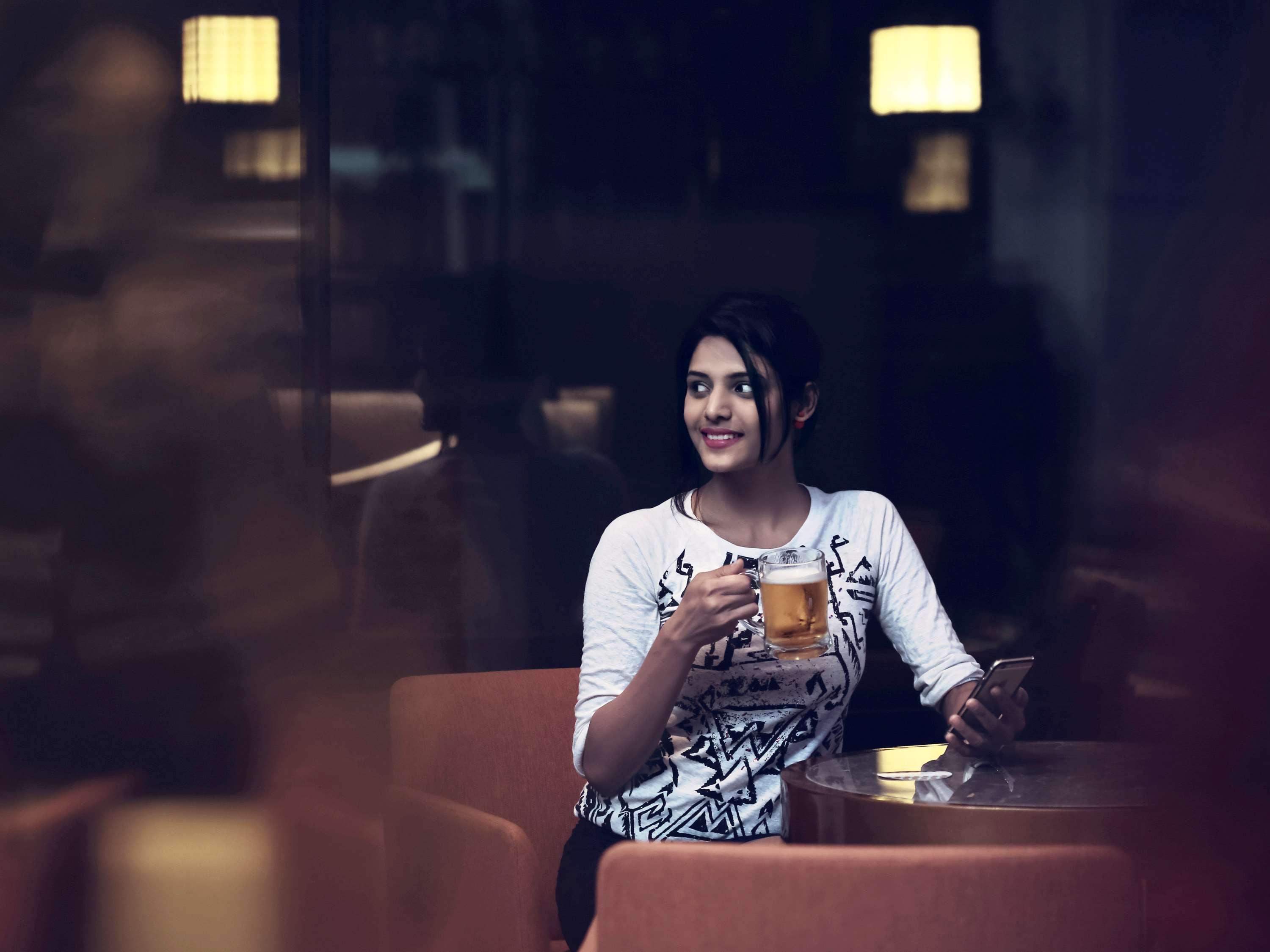 Mercure Hyderabad Kcp Banjara Hills, An Accor Hotel Exterior photo A woman drinking beer